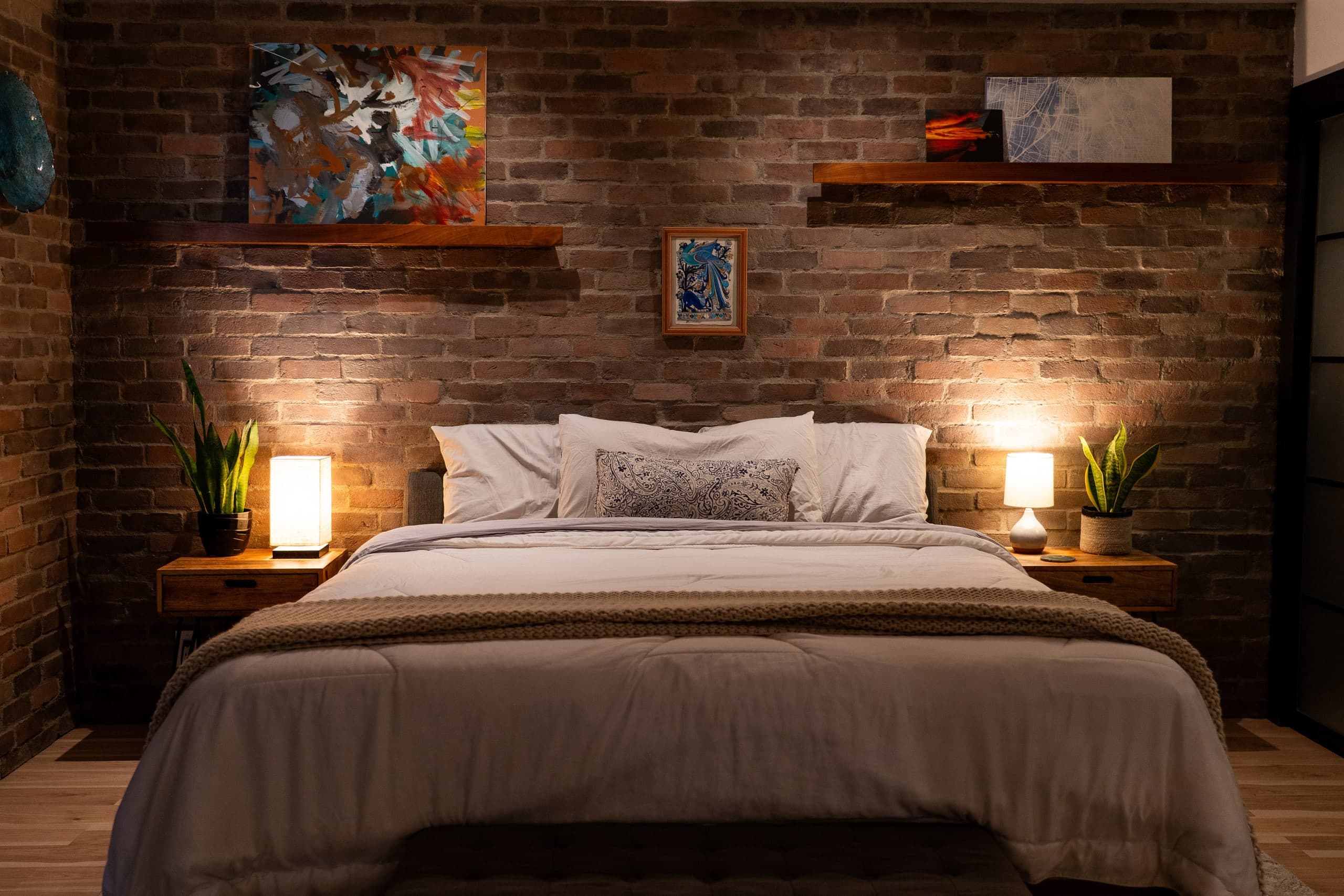 Bedroom with exposed brick and warm lamplight